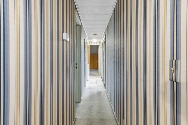 a view of a hallway with wooden shelves