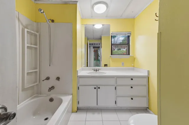 a bathroom with a bathtub sink and mirror