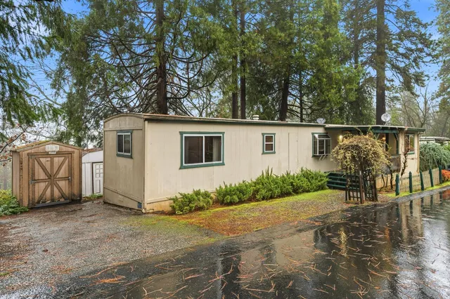 a view of a house with backyard and tree