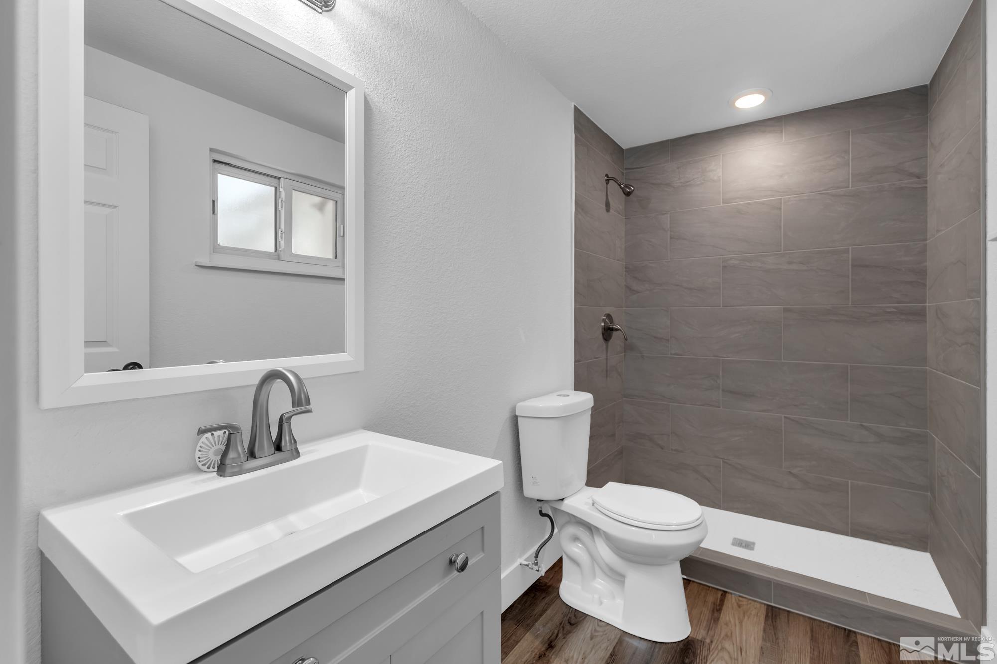 1750 Carlin Street Reno, NV 89503 - Photo 13 of 38 a bathroom with a toilet sink and mirror