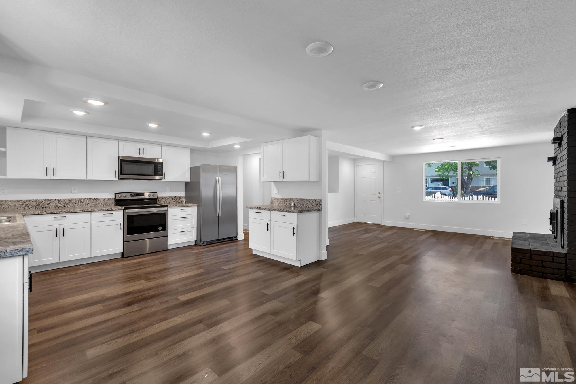 1750 Carlin Street Reno, NV 89503 - Photo 5 of 38 a kitchen with granite countertop a refrigerator and a stove top oven