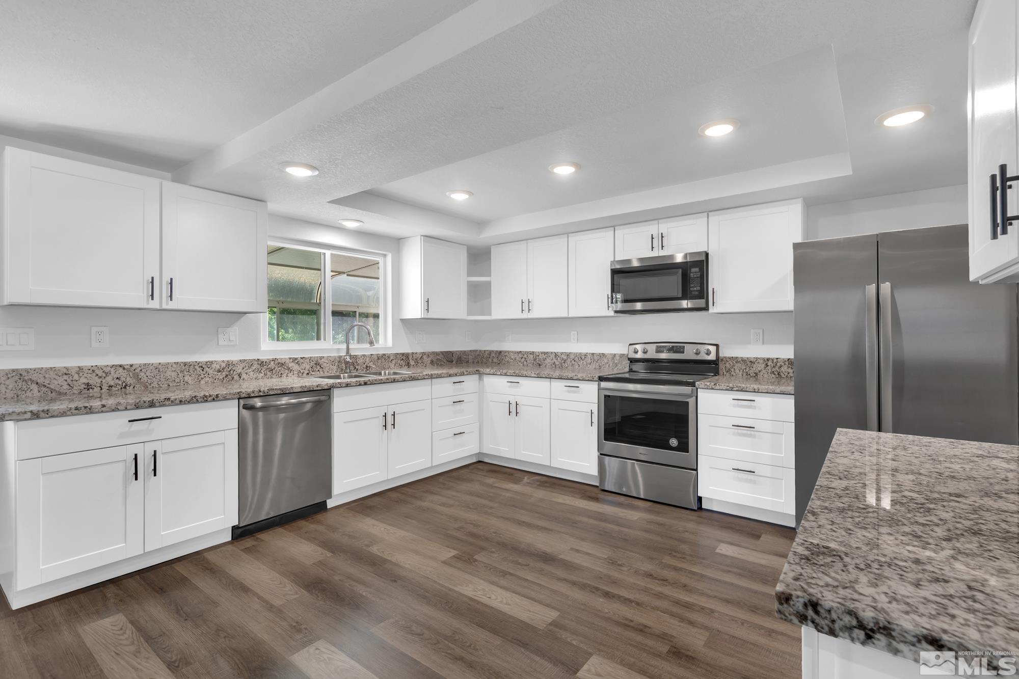 1750 Carlin Street Reno, NV 89503 - Photo 6 of 38 a kitchen with granite countertop a refrigerator stove top oven and sink