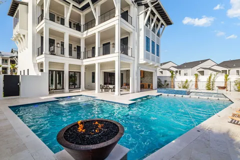a view of a house with backyard sitting area and swimming pool