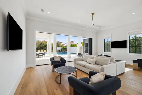 a living room with furniture a flat screen tv and a large window