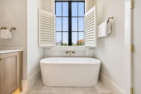 a white bath tub sitting in a bathroom next to a window