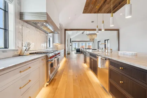 a large kitchen with stainless steel appliances lots of counter space and a sink