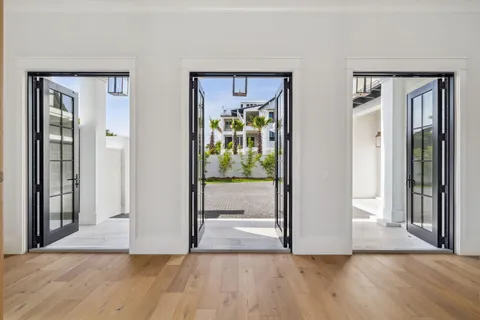 a view of a hallway with wooden floor and a livingroom