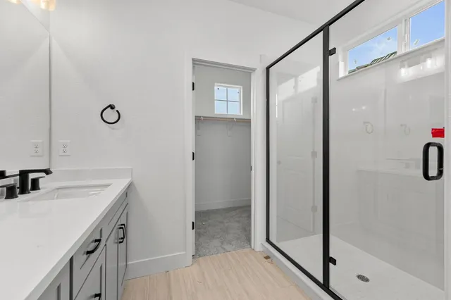 a walk in closet with clothes and shoes