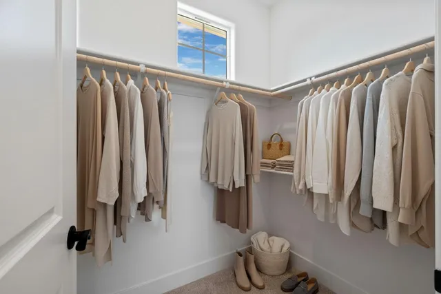 a view of walk in closet with clothes and shoes