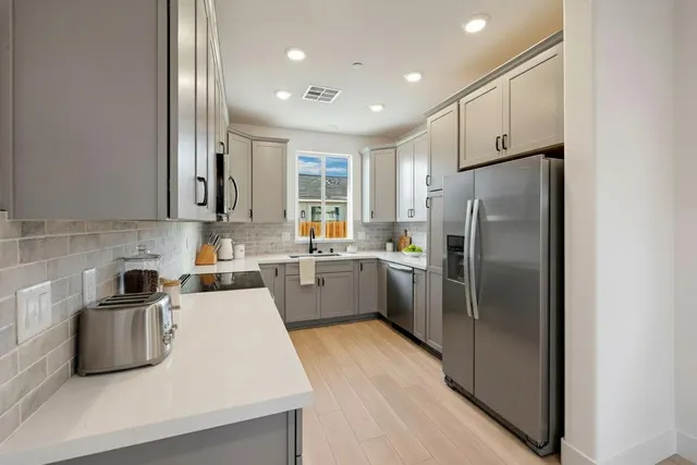 a kitchen with a refrigerator a sink and cabinets