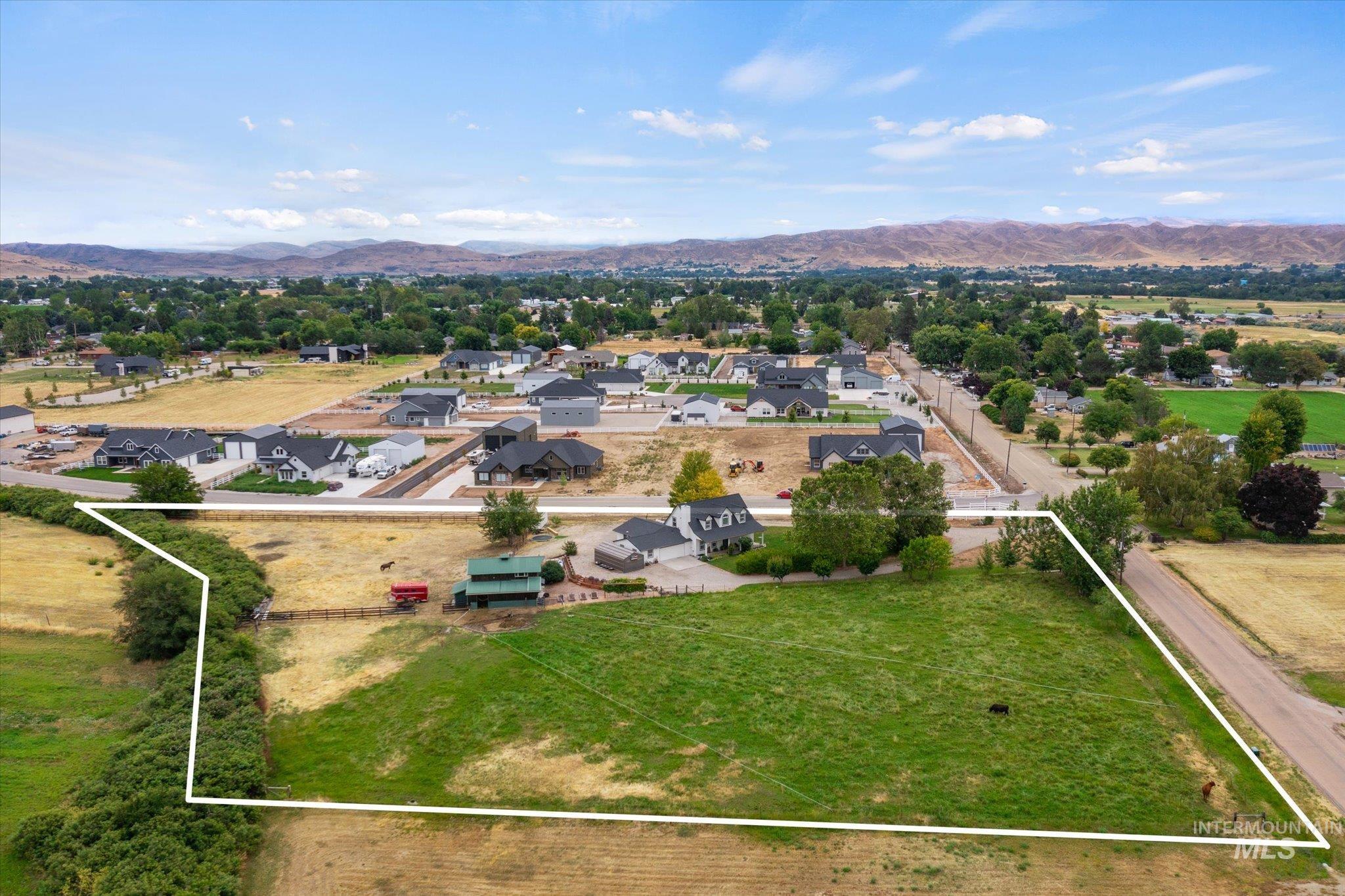 1140 Edgemont Road Emmett, ID 83617 - Photo 3 of 50 Expansive green acreage featuring a clear boundary line, multiple surrounding residential developments, and distant mountain backdrops