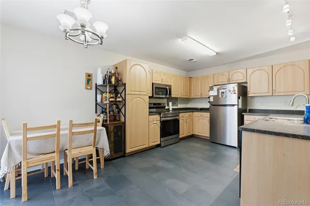 a kitchen with kitchen island granite countertop stainless steel appliances cabinets a sink and a island