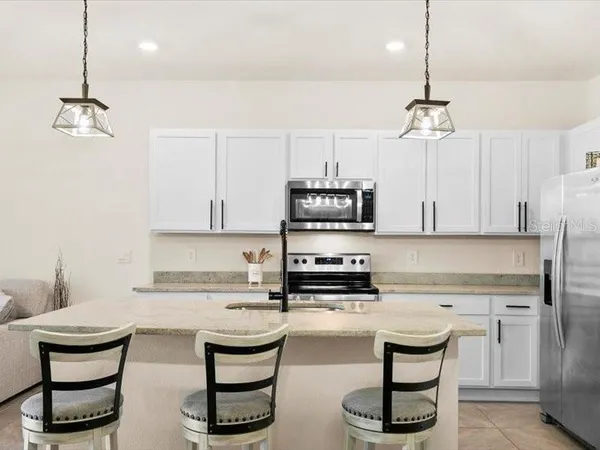 a kitchen with stainless steel appliances granite countertop a sink a stove and a refrigerator
