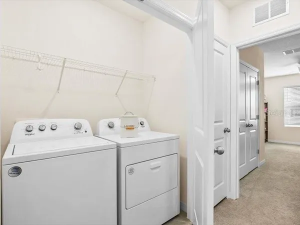 a living room with furniture and a refrigerator