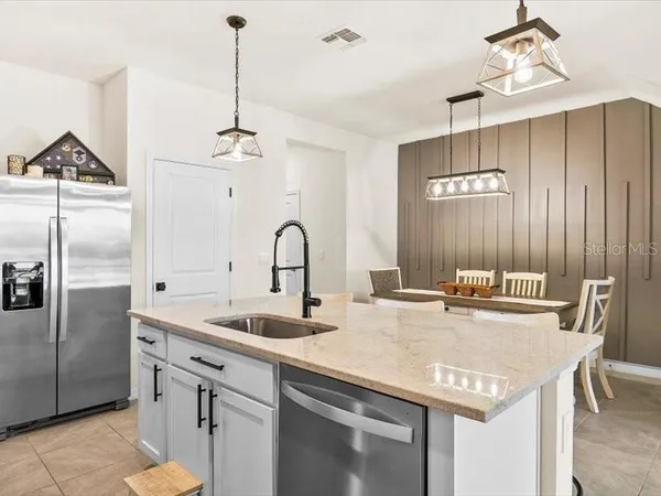 a kitchen with stainless steel appliances granite countertop a sink a center island and cabinets