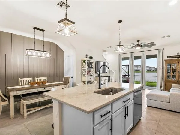 a kitchen with a stove a sink and chairs