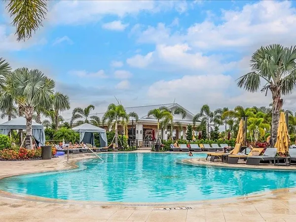 a view of swimming pool with outdoor seating and house in the background