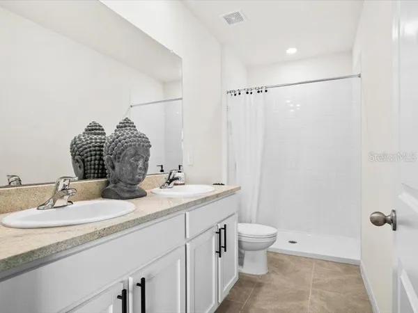 a bathroom with a granite countertop sink a toilet and a mirror