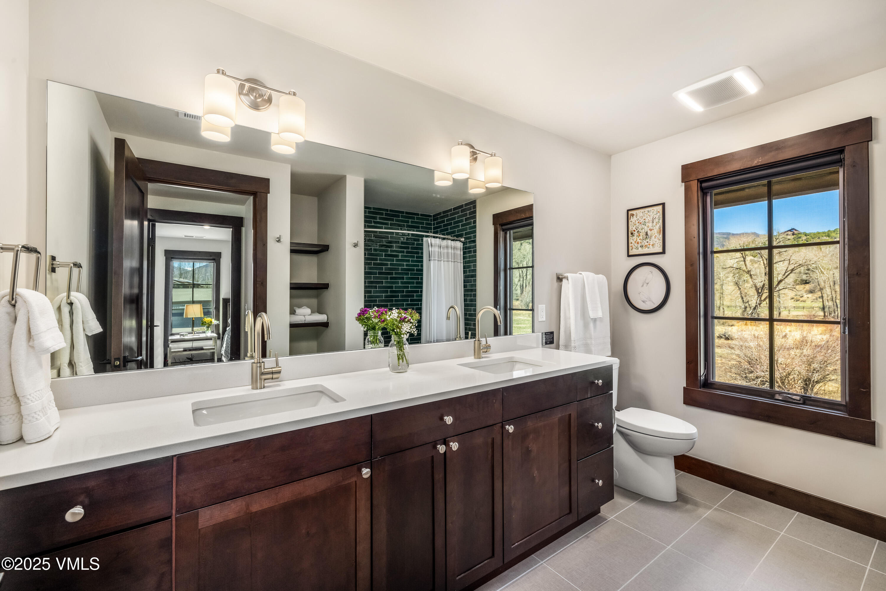 687 Hunters View Lane Eagle, CO 81631 - Photo 22 of 43 a bathroom with a granite countertop sink a large mirror a toilet and a window
