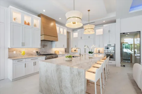 a open kitchen with stainless steel appliances kitchen island granite countertop a sink and a stove
