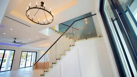 a view of staircase with lots of frames on wall and a large window
