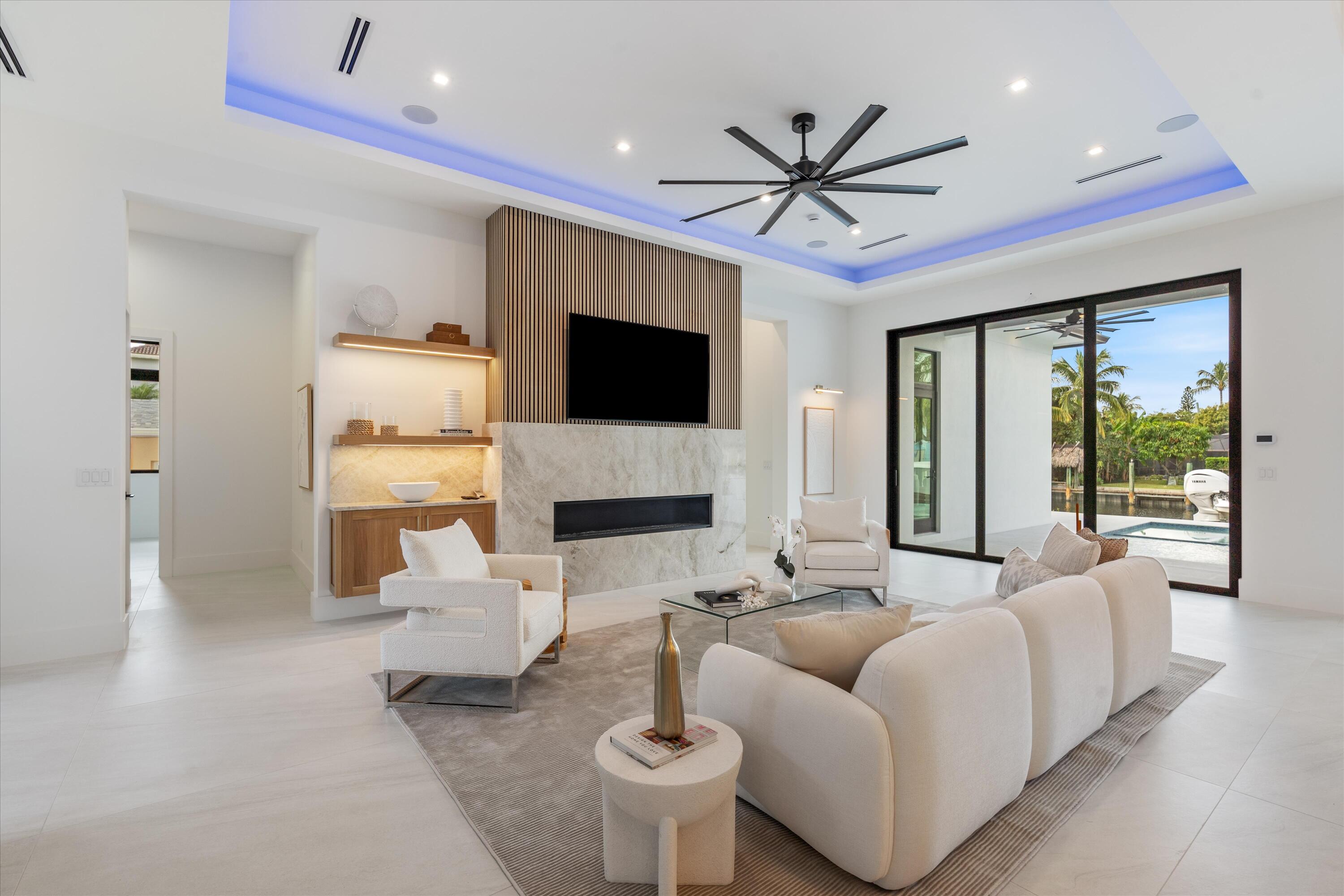 11331 Avery Road Palm Beach Gardens, FL 33410 - Photo 4 of 110 a living room with furniture a fireplace and a flat screen tv
