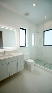 a bathroom with a granite countertop toilet sink and mirror