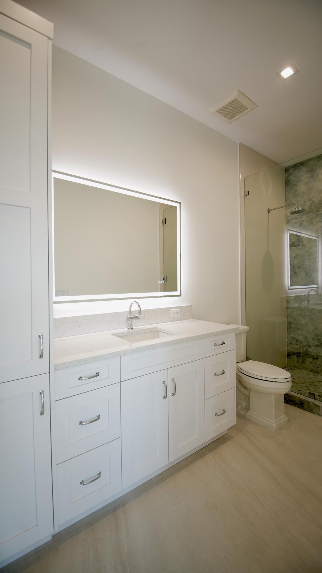 11331 Avery Road Palm Beach Gardens, FL 33410 - Photo 77 of 110 a spacious bathroom with double sink a toilet a window and mirror