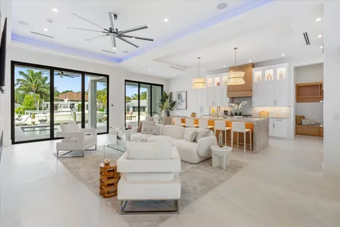 a large kitchen with kitchen island a large counter space a sink appliances and windows