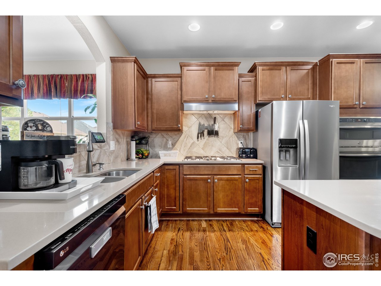 5865 Quarry Street Timnath, CO 80547 - Photo 3 of 47 a kitchen with granite countertop stainless steel appliances a sink and counter