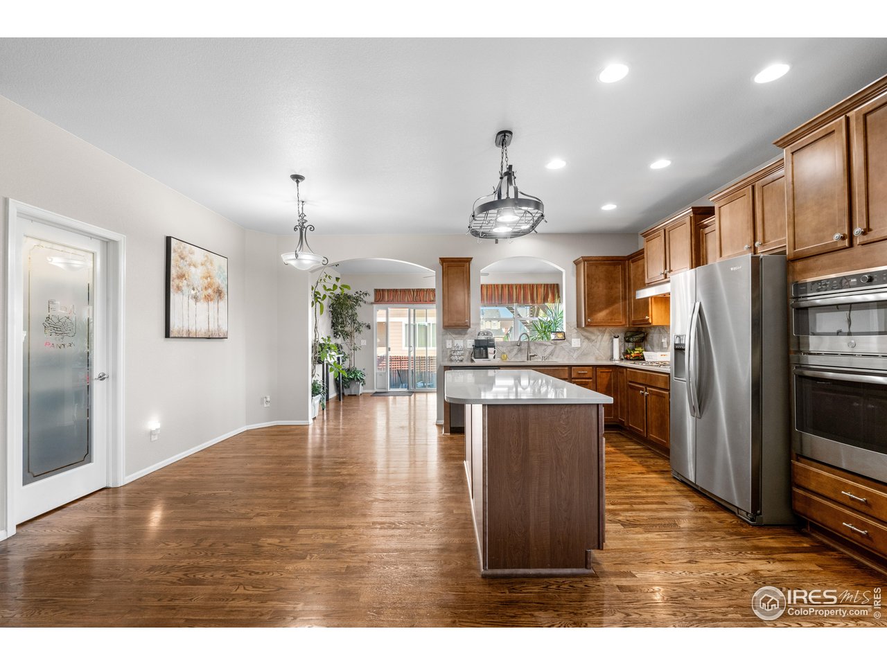 5865 Quarry Street Timnath, CO 80547 - Photo 5 of 47 a kitchen with stainless steel appliances granite countertop a refrigerator a sink dishwasher a stove with wooden floor