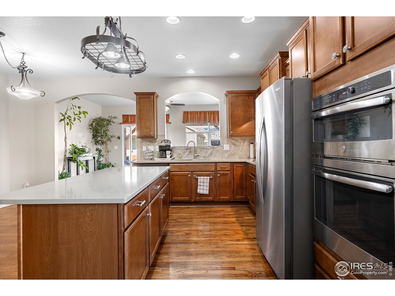 5865 Quarry Street Timnath, CO 80547 - Photo 6 of 47 a kitchen with kitchen island granite countertop a sink cabinets and stainless steel appliances