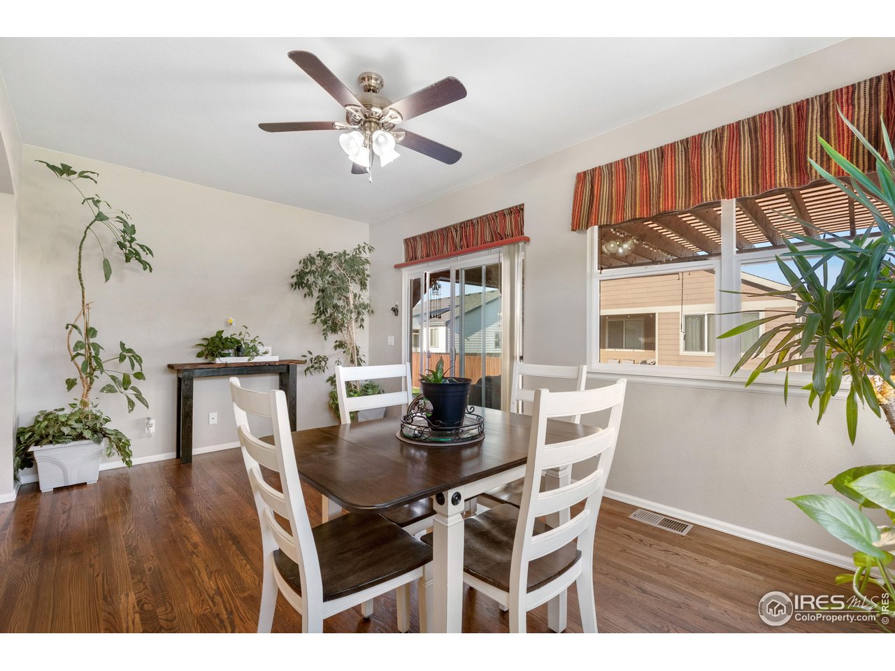 5865 Quarry Street Timnath, CO 80547 - Photo 9 of 47 a dining room with furniture potted plants and wooden floor