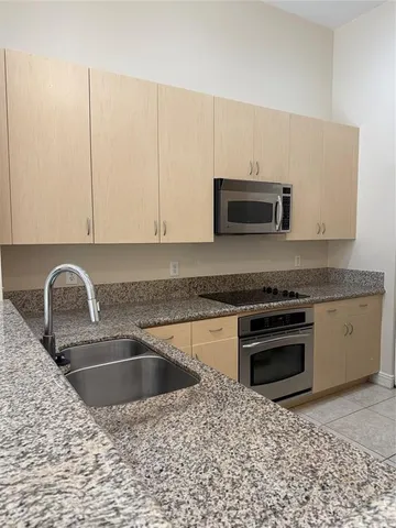 a kitchen with granite countertop a sink and a stove