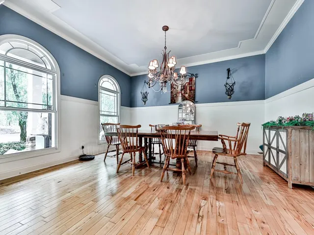 a kitchen with stainless steel appliances granite countertop a sink a stove and a wooden floor