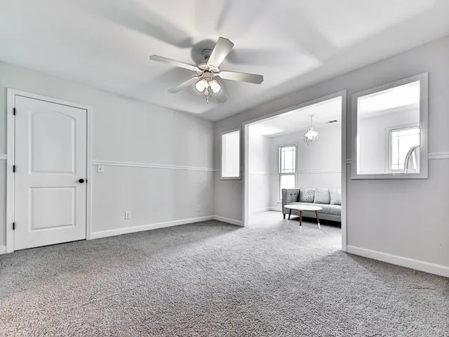 a backyard of a house with plants and large tree