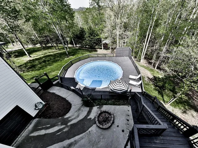 an aerial view of residential house with outdoor space and trees all around