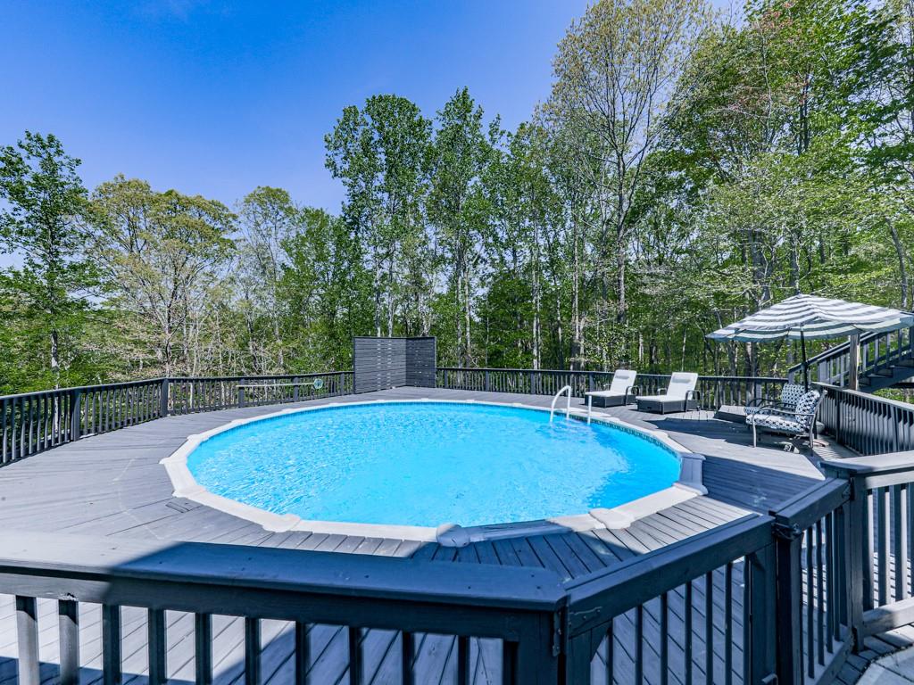 1141 Addington Lane Waleska, GA 30183 - Photo 59 of 105 a view of a swimming pool with a table and chairs under an umbrella