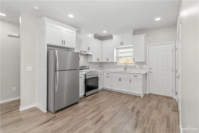 a kitchen with a white refrigerator a sink and cabinets
