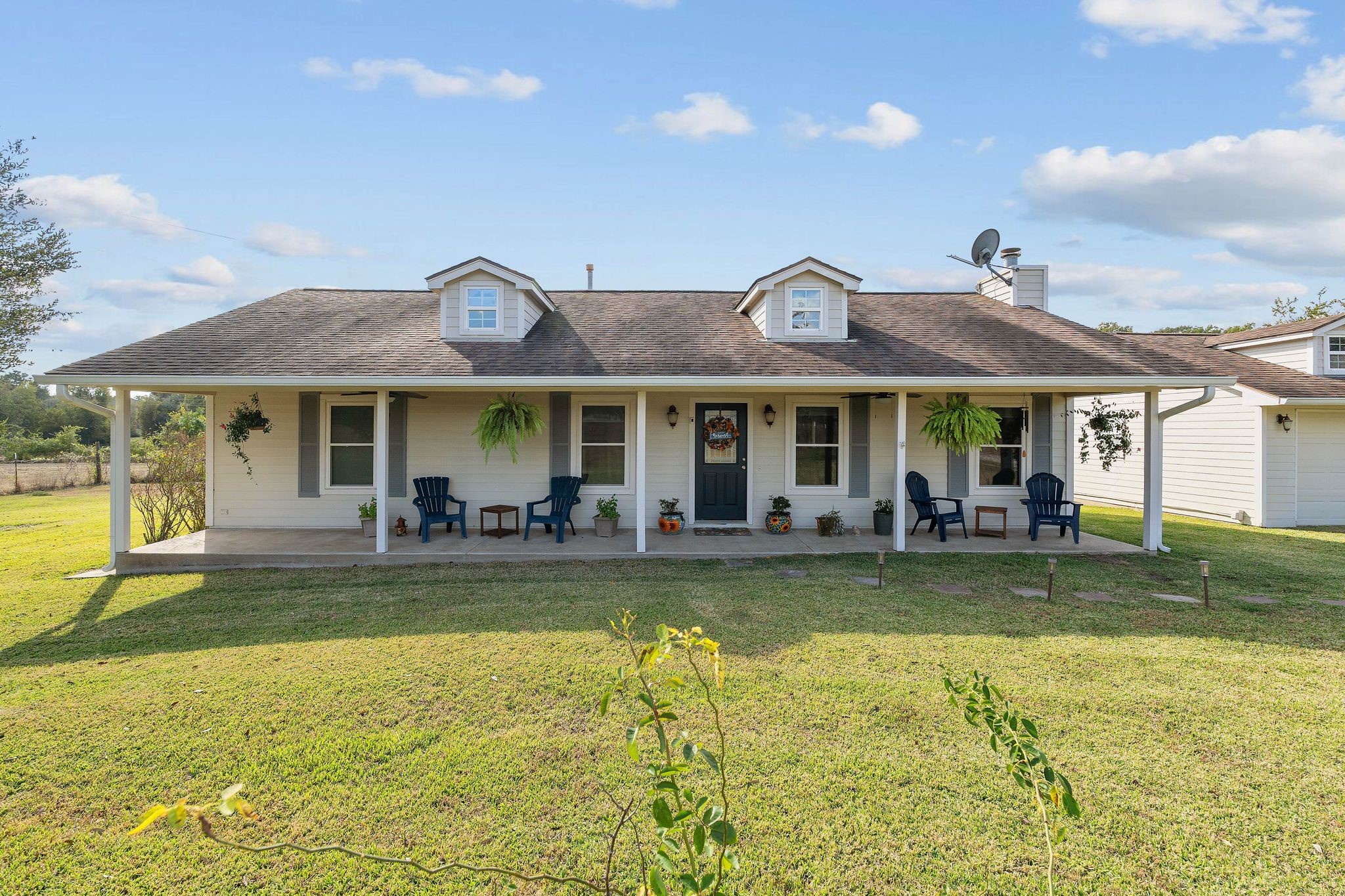 Beautiful front exterior view showcasing the home’s wide façade, manicured lawn, and inviting curb appeal.
