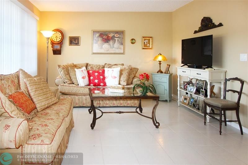 1055 Cambridge C, Unit 1055 Deerfield Beach, FL 33442 - Photo 2 of 52 a living room with furniture and a flat screen tv