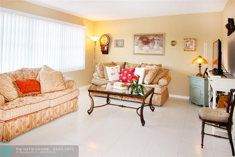 1055 Cambridge C, Unit 1055 Deerfield Beach, FL 33442 - Photo 3 of 52 a living room with furniture and a flat screen tv