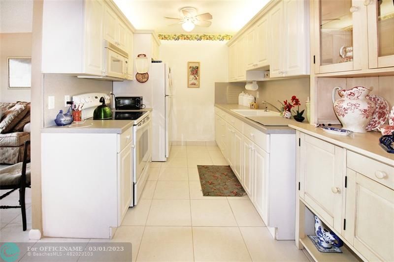 1055 Cambridge C, Unit 1055 Deerfield Beach, FL 33442 - Photo 8 of 52 a kitchen with stainless steel appliances cabinets and a window