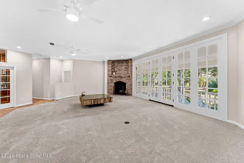 a view of an empty room with fireplace and a window