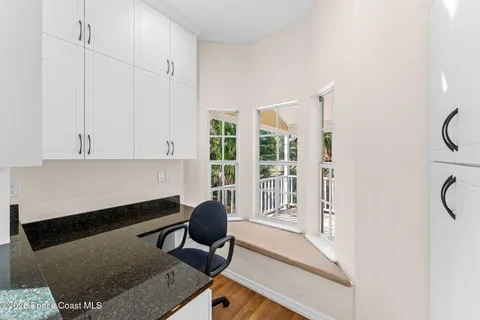 an empty room with windows and ceiling fan