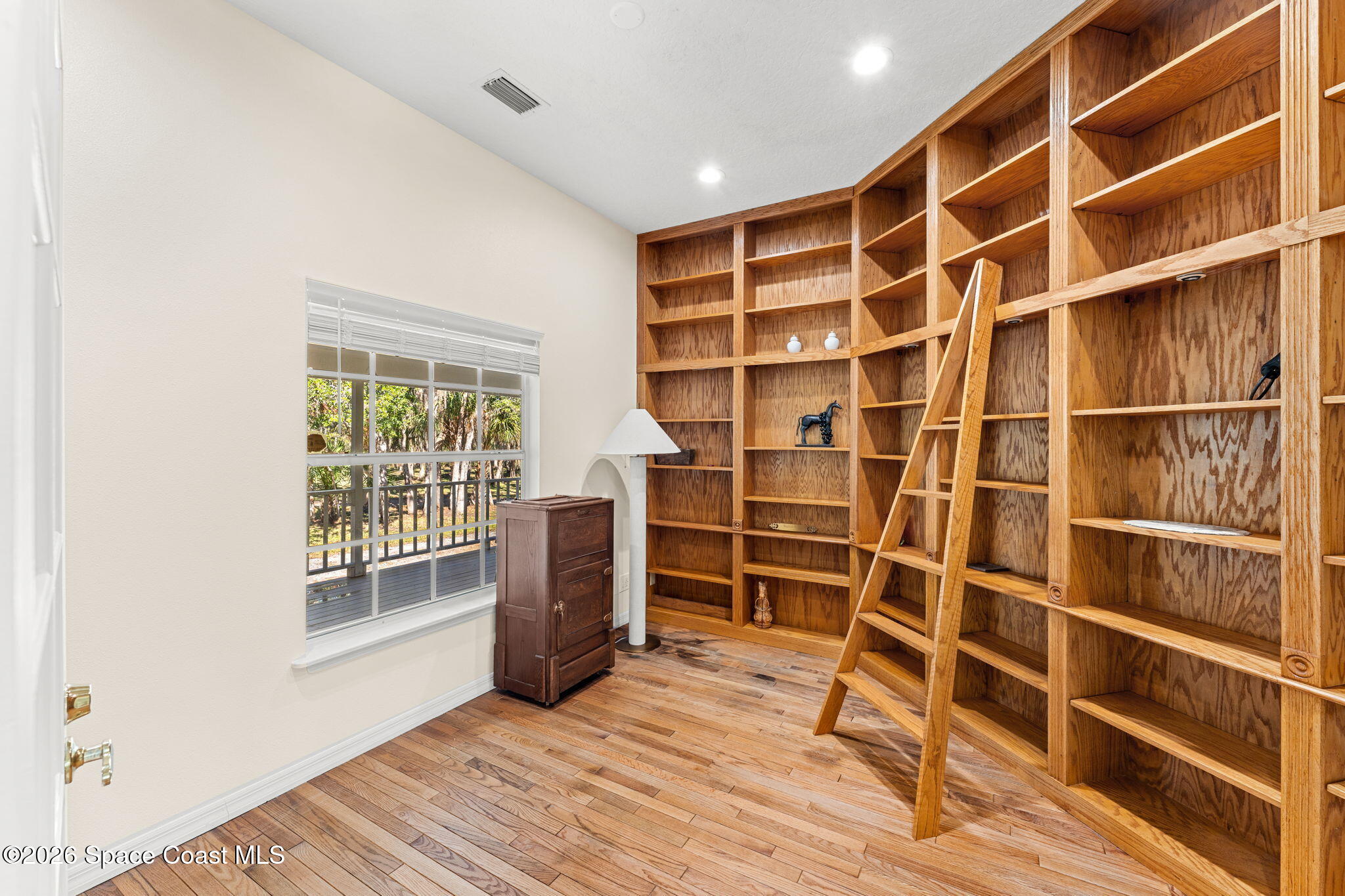 1325 Chase Hammock Road Merritt Island, FL 32953 - Photo 28 of 83 a view of an empty room with wooden floor and a window