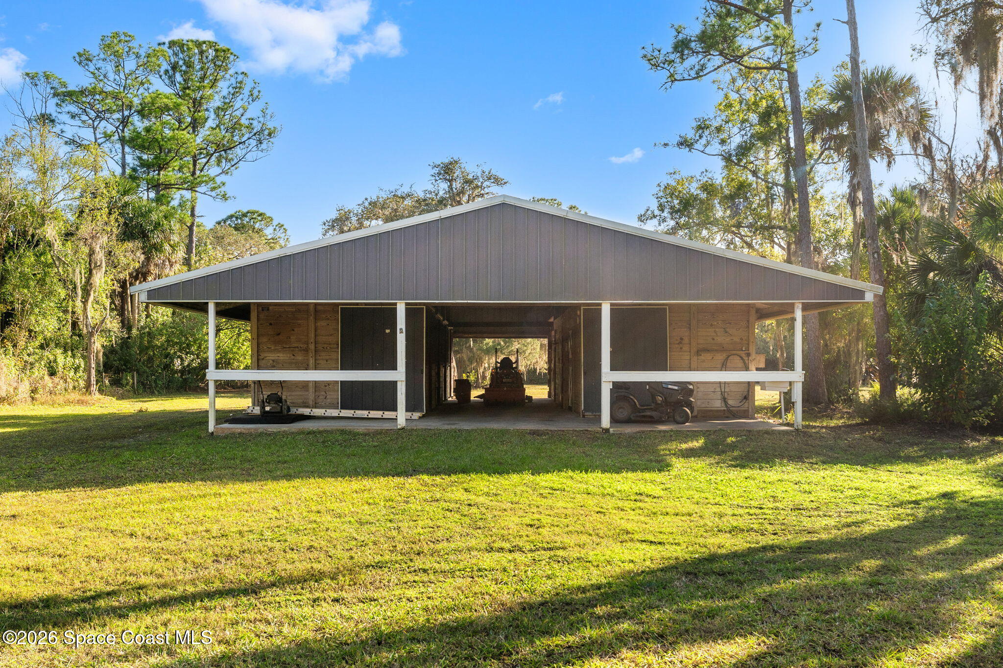 1325 Chase Hammock Road Merritt Island, FL 32953 - Photo 66 of 83 a view of a house with a swimming pool and a large tree