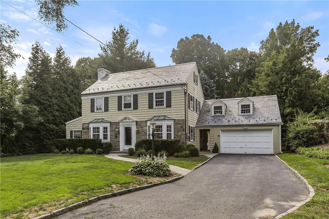 253 Fox Meadow Road Scarsdale, NY 10583 - Photo 1 of 1 a front view of a house with a garden and trees