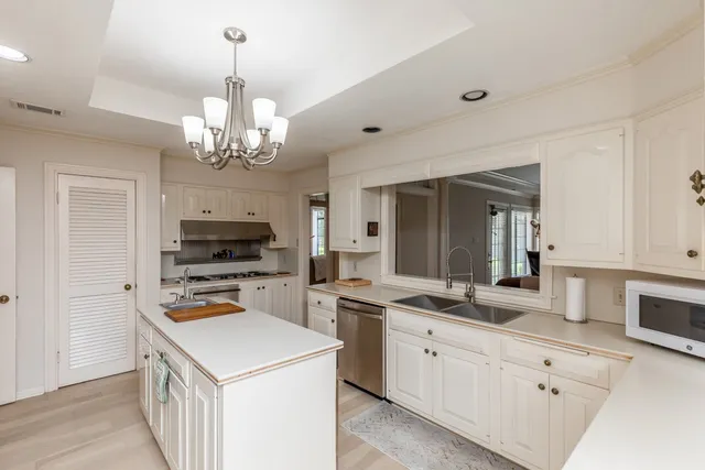 a kitchen that has a lot of cabinets and stainless steel appliances