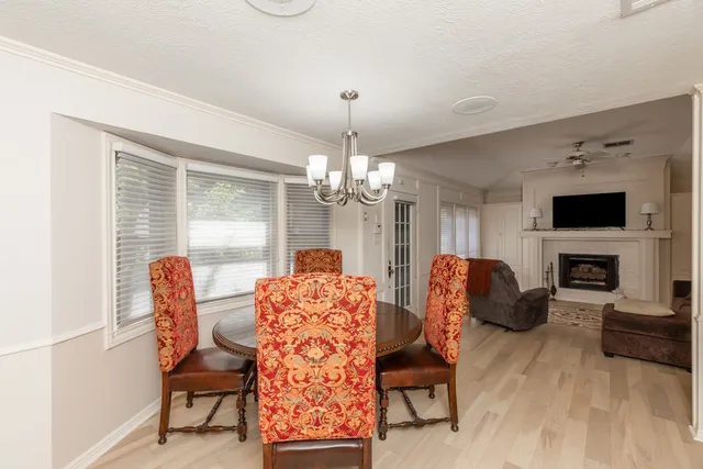 a dining room with furniture a fireplace and wooden floor